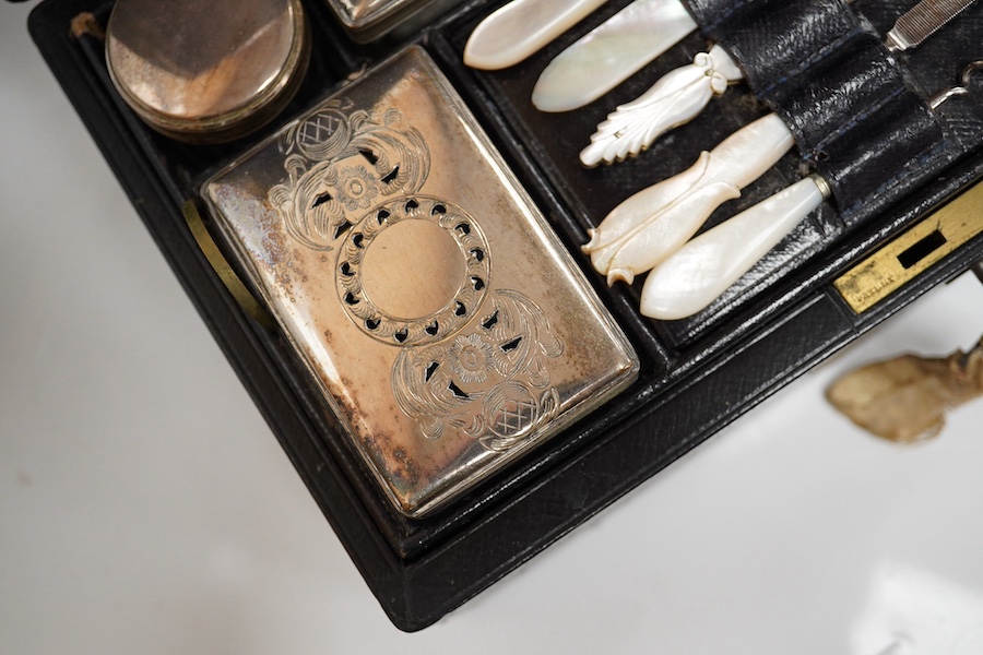 A Victorian leather vanity case with fitted interior to include white metal mounted glass bottles and mother of pearl mounted implements, with key, 27.5cm wide. Condition - fair, handle broken